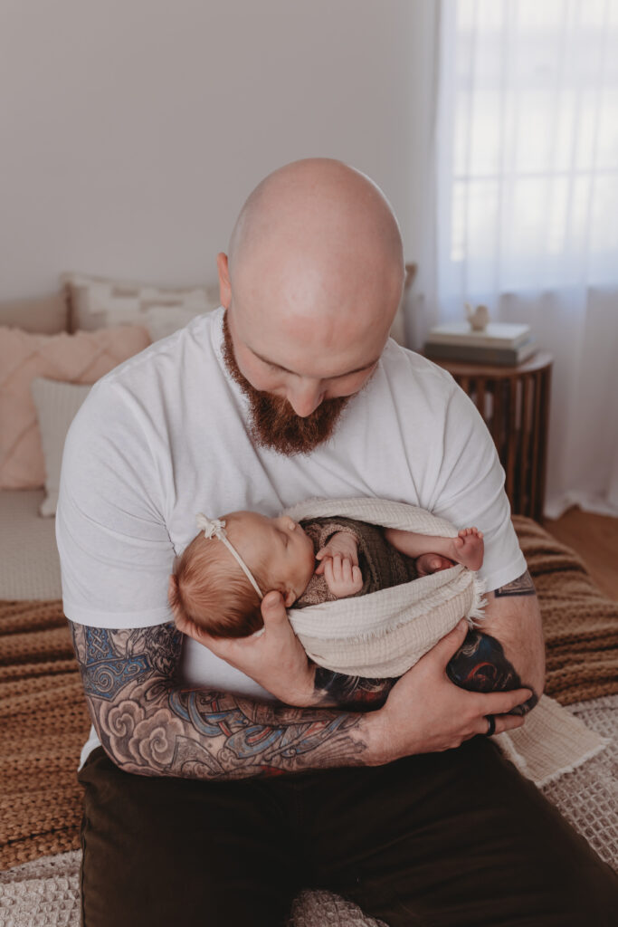 father holding his newborn baby during a family photography session