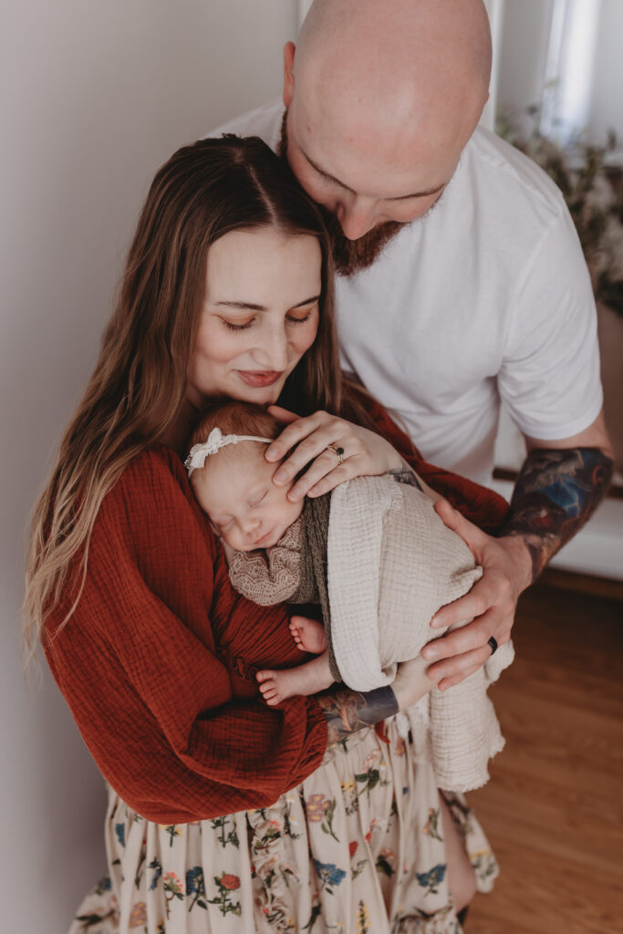 parents gently cradling their newborn together